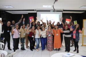 um grupo de pessoas reunidas com os braços levantados e felizes